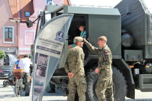 Dziecko siedzące w wojskowej ciężarówce i dwaj żołnierze