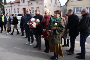 Władze lokalne PIS składają kwiaty przd tablicą upamiatniającą kaźń żołnierzy wyklętych